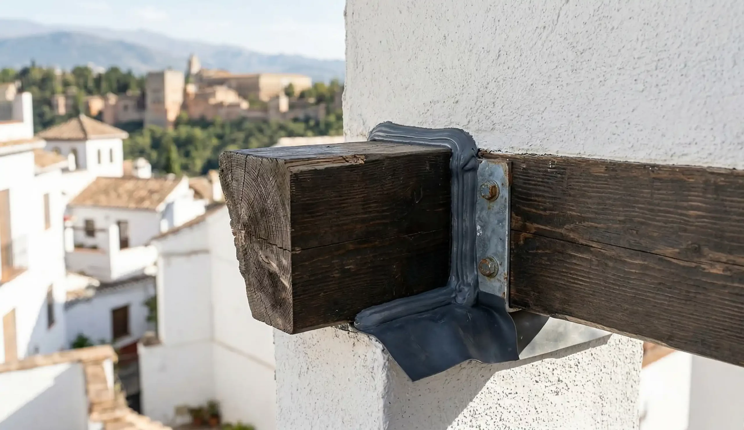 Detalle de sellado técnico en encuentro de viga de madera y muro para evitar humedades.